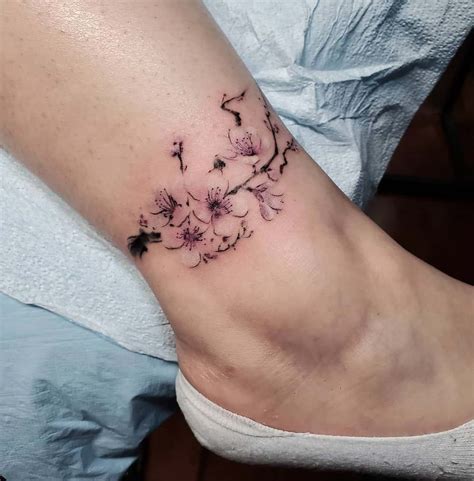 Small blue flower tattoo on the inner foot.