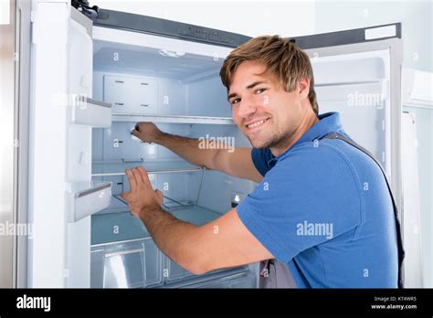 Smiling technician examining a refrigerator