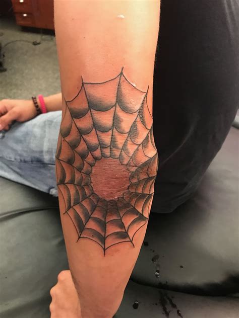 Spider web inked around the left elbow by tattooist