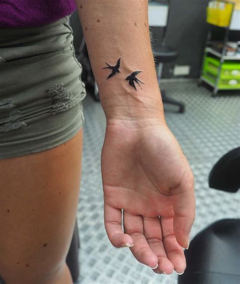 Wrist tattoo of a swallow on Samantha.