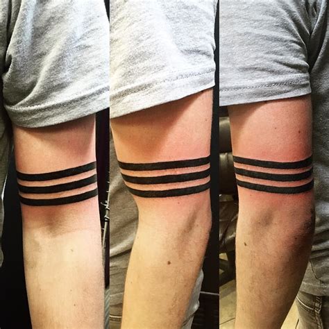 Minimalist black armband tattoo on the right forearm