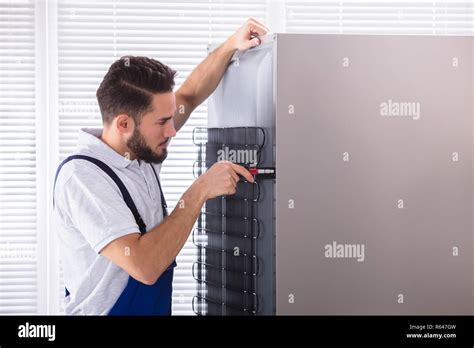 Technician Fixing Refrigerator
