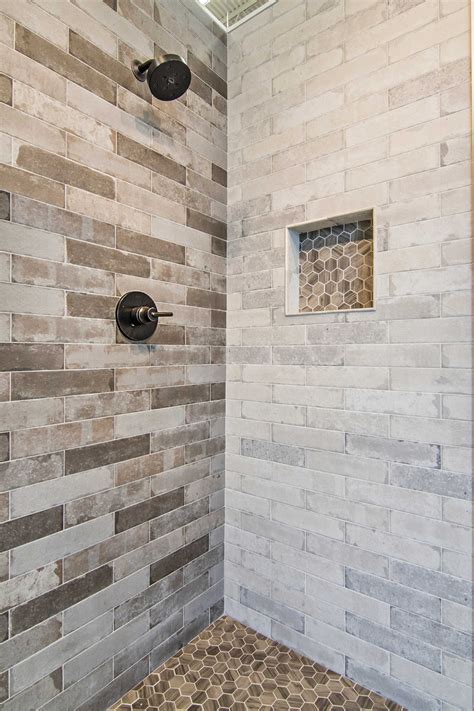 Custom tiled shower with porcelain tiles that look like marble, pebbles on the shower floor