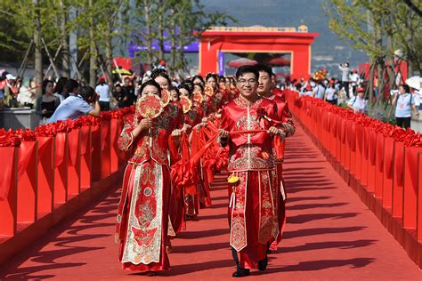 A poised woman in traditional Chinese garb presents items on a table, suggesting ritual and tradition