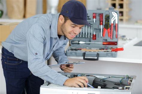 Washing machine repair technician checking a machine