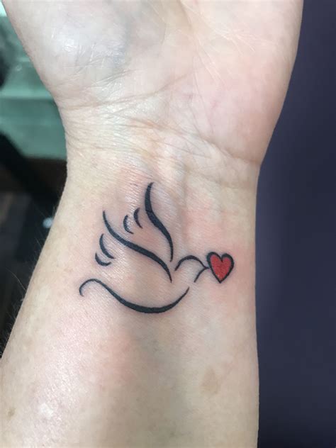 White inked dove tattoo on the wrist