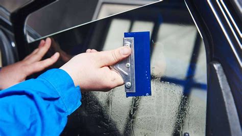 Image of a person installing window tint on a car