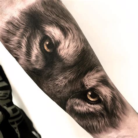 Wolf eyes tattoo on the left forearm.