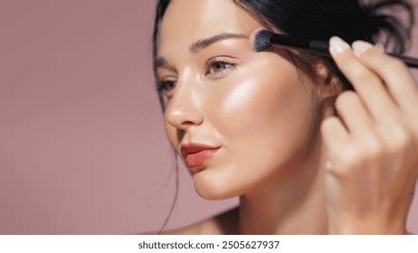 Woman applying highlighter to her face