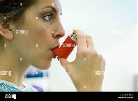 Woman with asthma using inhaler