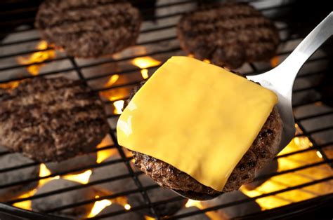 adding cheese to a burger patty