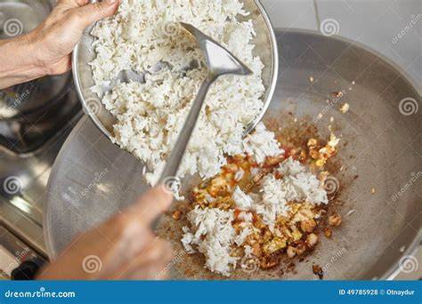 adding rice to wok