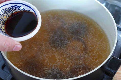 adding soy sauce and chicken broth