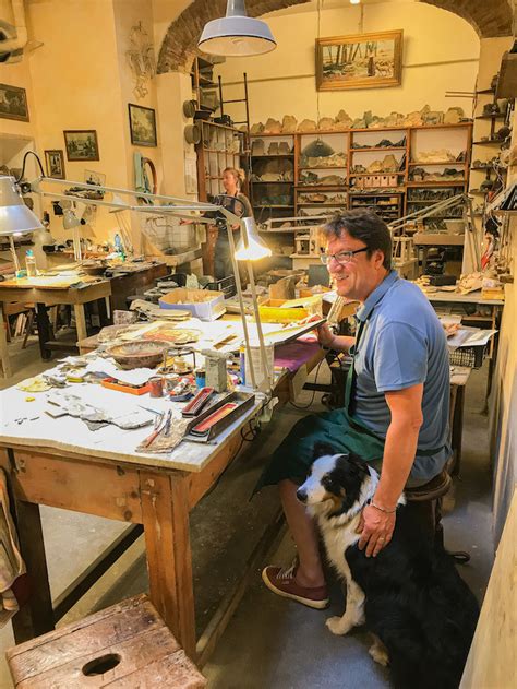 A cyclist entering a charming shop or artisan workshop in a bustling Italian market, with colorful produce and handmade crafts around.