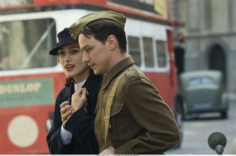A person standing in a circle of people, hands raised in celebration
