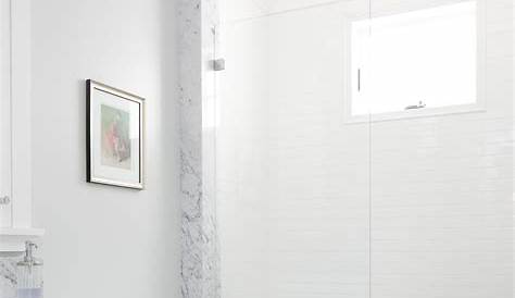 This white bathroom features a unique white and gray tile pattern, a