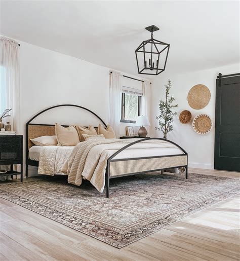 A black bedroom with organic touches such as potted plants and wooden accents