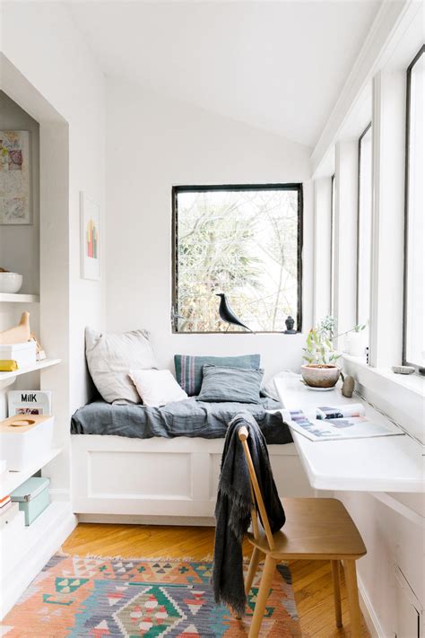 A black bedroom with a cozy reading nook and a view of the night sky