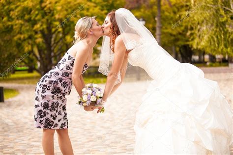 bride and bridesmaid kiss