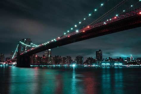 The Brooklyn Bridge illuminated at night, a stunning sight to behold.
