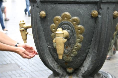 People drinking water from a street tap, Barcelona, Spain Stock Photo