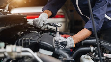 Alt Text: Car Owner Performing Routine Maintenance on Vehicle