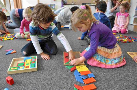 A classroom setting with children happily engaged in solving printable puzzles.