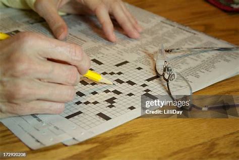 Crossword puzzle laid on a table in a bright, cheerful setting, surrounded by coffee and reading glasses.