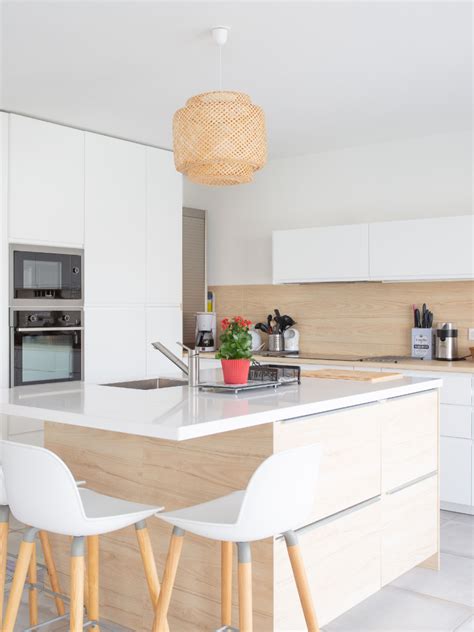 Dans cette cuisine moderne blanc et bois au sein d’un appartement