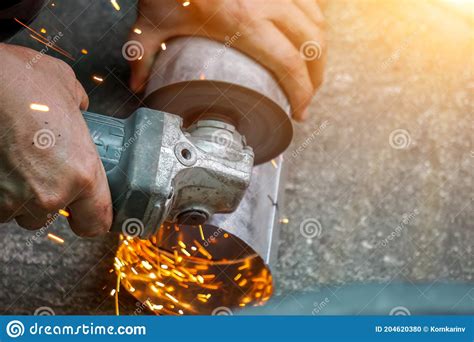 Closeup Hands of Laborer Holding Electric Angle Grinder Working Cutting