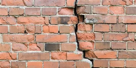 Damaged brick wall showing cracks