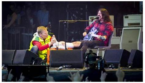 Dave Grohl performs with his injured leg propped up on a throne of