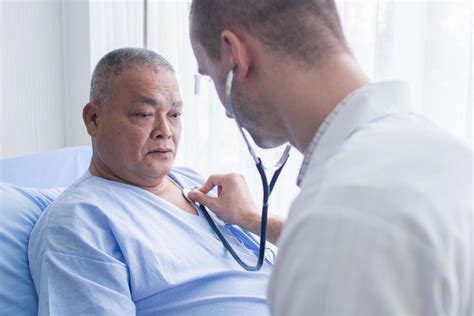 Doctor Using Stethoscope on Patient