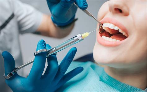 Dentist Giving An Injection Of Anesthesia To The Patient Stock Photo