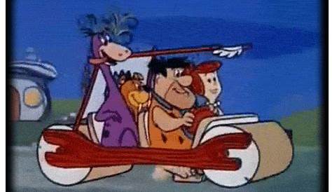 FRED FLINTSTONE AND HIS FAMILY IN A CAR, THEY ARE GOING TO