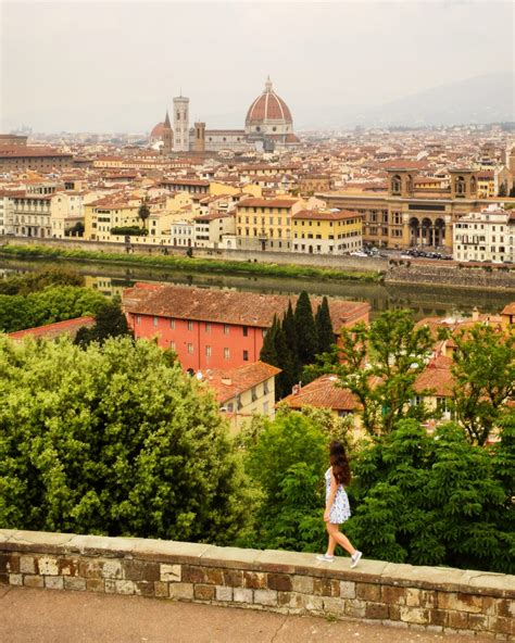 A tourist taking a photo of a bridge in Florence, Italy, while on a walking tour