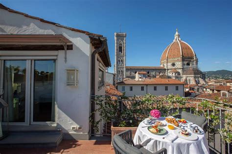 An elegantly furnished hotel room overlooking a scenic cityscape in Florence, Italy.