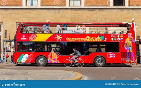 A group of people looking out the window of a classic red double-decker bus