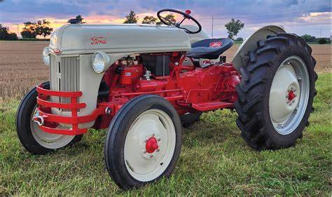 A classic Ford 8N tractor in a field, showcasing its iconic design and robust build