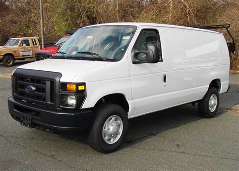 A robust Ford E-Series van parked on a sunny street, showcasing its classic design and practicality.