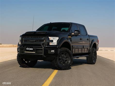A Ford F-150 modified to resemble a Black Ops truck, featuring off-road tires and a custom bumper.
