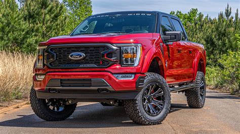 A rugged Ford F-150 lifted with large tires and aggressive stance on an off-road trail