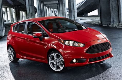 A bright red Ford Fiesta hatchback parked on a city street