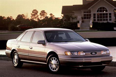 A well-maintained Ford Taurus 1990 sedan parked on a street