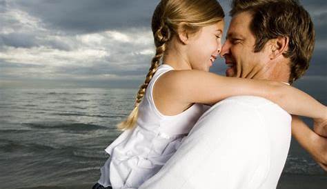 Padre E Figlia Che Guardano Album Di Foto Sul Letto Fotografia Stock