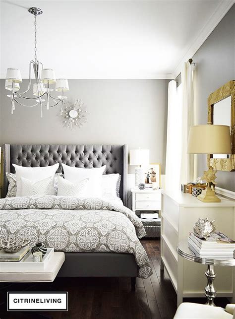 Image of a grey bedroom with a tufted headboard and crystal chandelier