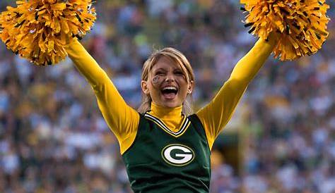 Photo: A Packers cheerleader waves pom poms against the Ravens in Green