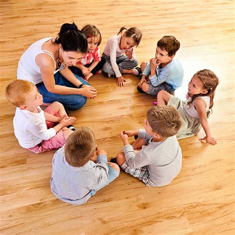 Image of a group of children sitting in a circle, talking and smiling