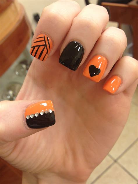 Picture Of orange and black glitter nails with bats for a bold