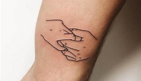 Hand holding three fingers and flowers tattoo on the arm